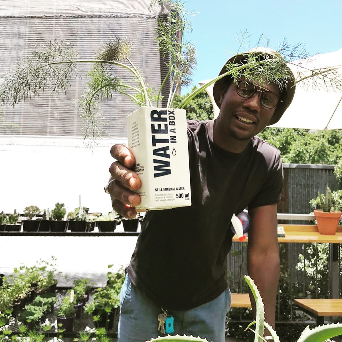 Jozi Food Farmer holding a Water In A Box carton upcycled into a planter